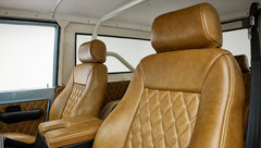 Close-up of two brown leather front seats with diamond stitching in Classic Ford Bronco