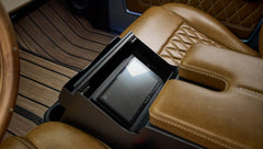 Brown leather armrest with diamond stitching and a built-in touchscreen display in center console