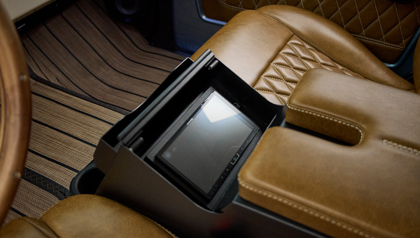 Brown leather armrest with diamond stitching and a built-in touchscreen display in center console