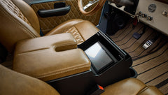 Brown leather armrest and stitched leather seats with touchscreen display on the center console