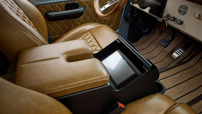 Brown leather armrest and stitched leather seats with touchscreen display on the center console