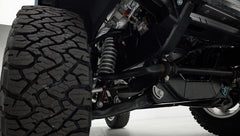Close-up of Classic Ford Bronco suspension and large off-road tire showing coil spring and control arm