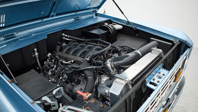 Open hood view of Classic Ford Bronco engine compartment with detailed mechanical components inside