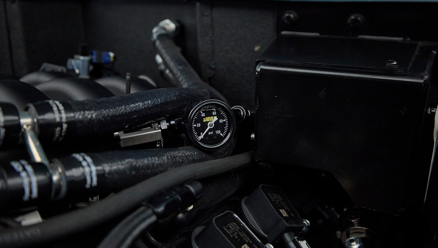 Close-up of pressure gauge and hoses within the engine compartment of the Classic Ford Bronco