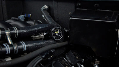 Close-up of pressure gauge and hoses within the engine compartment of the Classic Ford Bronco