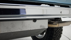 Classic Ford Bronco rear bumper with under-mounted small backup camera and visible exhaust pipe
