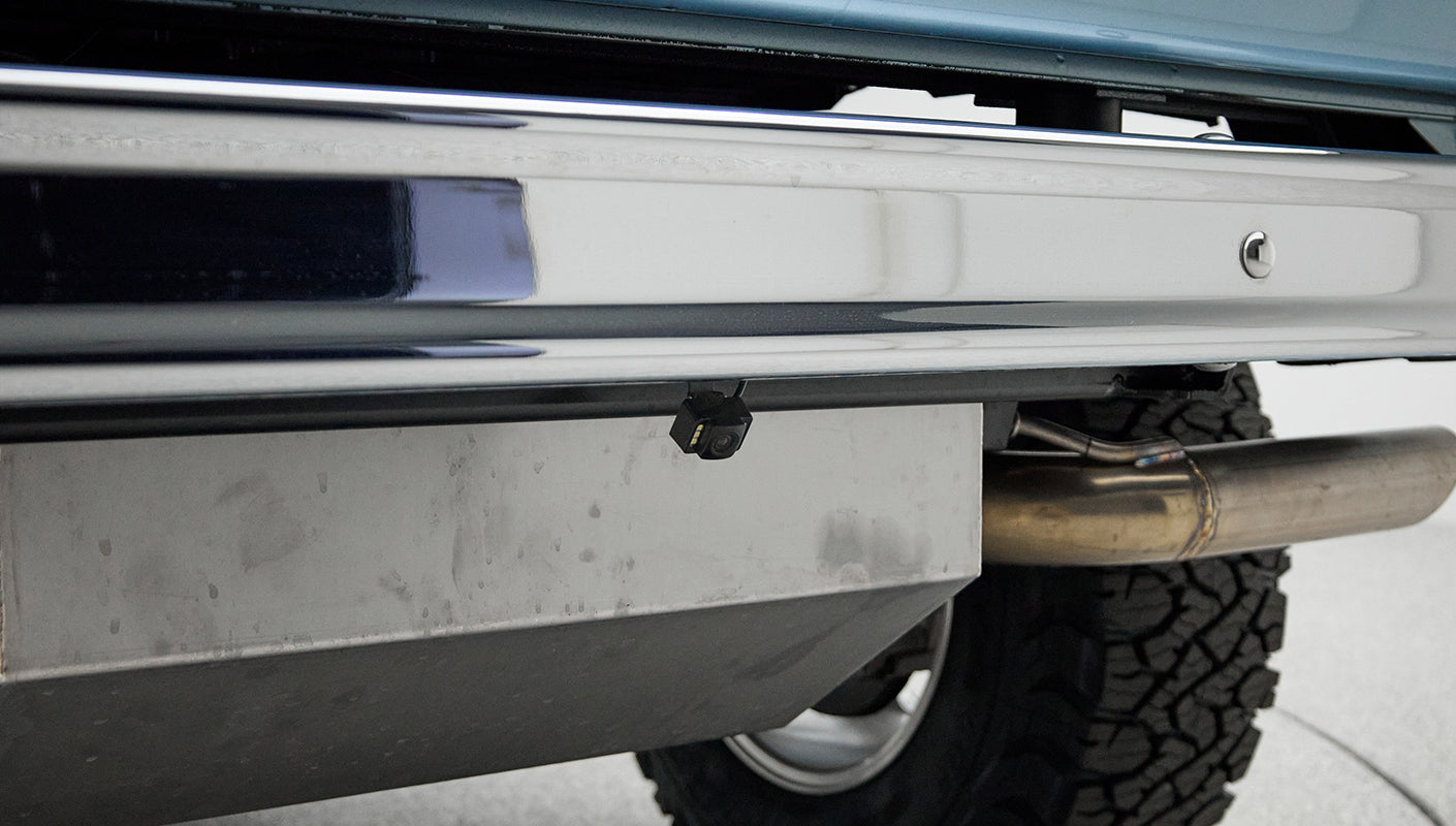 Classic Ford Bronco rear bumper with under-mounted small backup camera and visible exhaust pipe