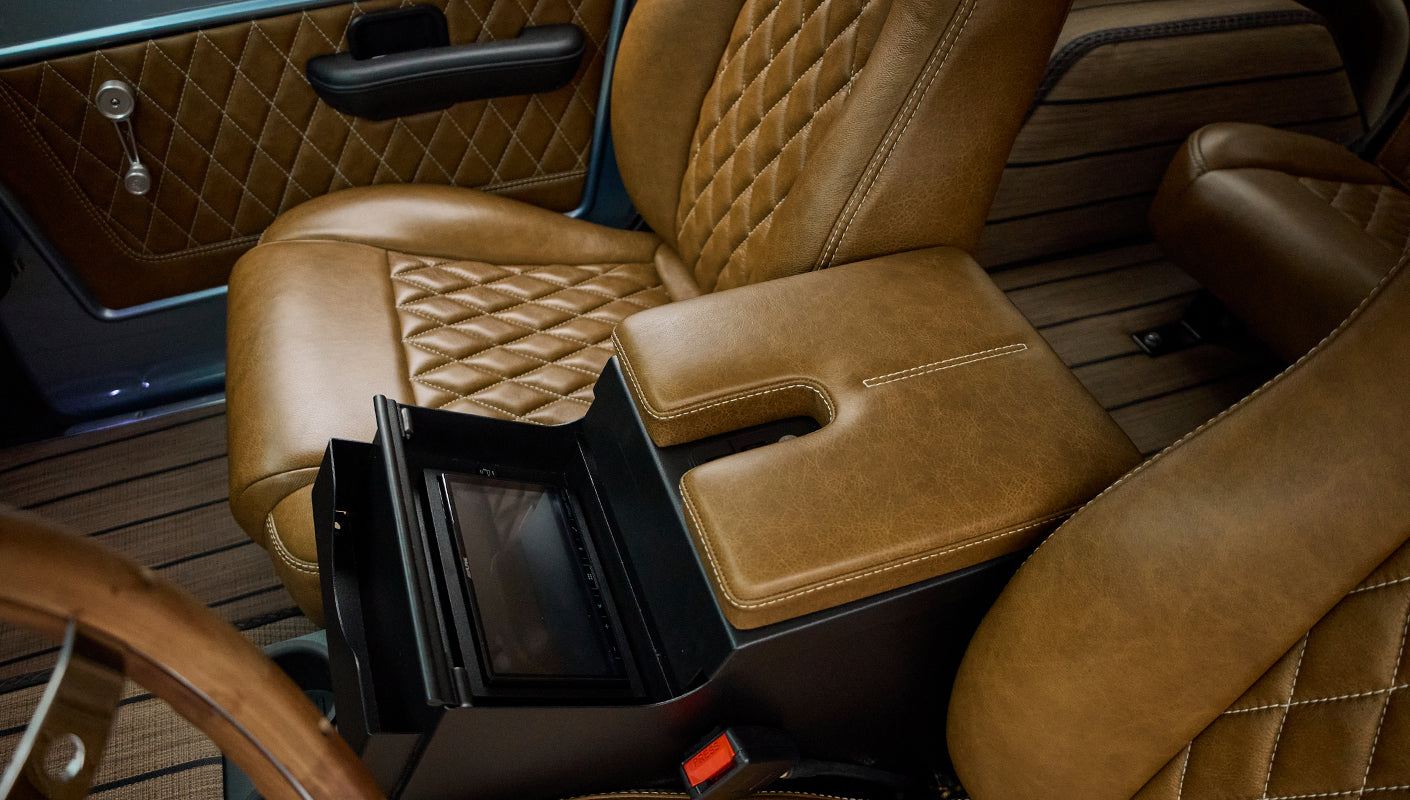 Center console of Classic Ford Bronco with brown leather armrest and integrated screen