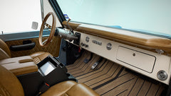 Classic Ford Bronco front interior with brown leather seats, dashboard, and steering wheel
