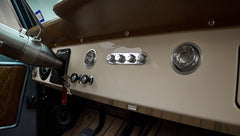 Classic Ford Bronco dashboard controls and vents with cream panel and black knobs