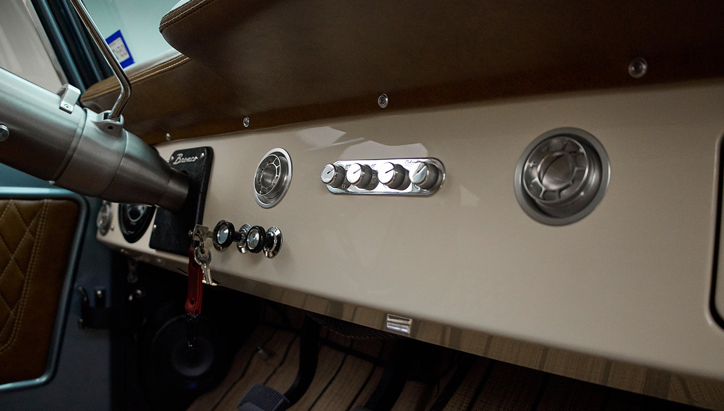 Classic Ford Bronco dashboard controls and vents with cream panel and black knobs