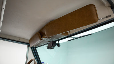 Light brown padded sun visor and rearview mirror inside Classic Ford Bronco