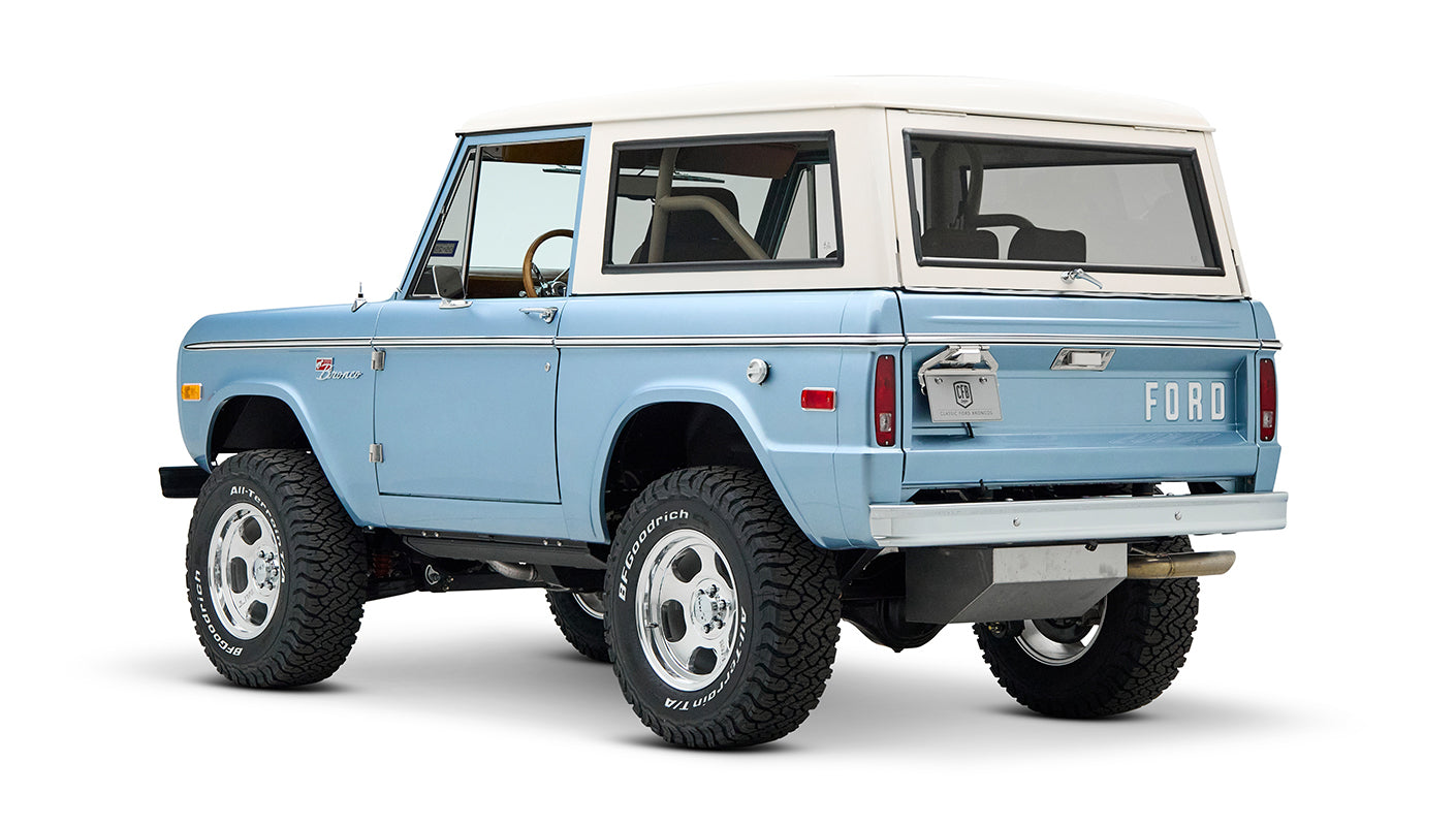 Rear three-quarter view of Classic Ford Bronco Brittany Blue with white hardtop and chrome wheels