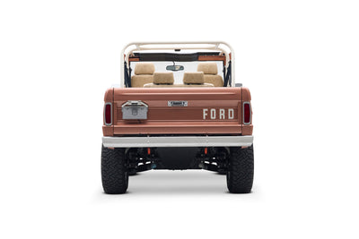 Rear view of Classic Ford Bronco in peach color with FORD lettering on the tailgate