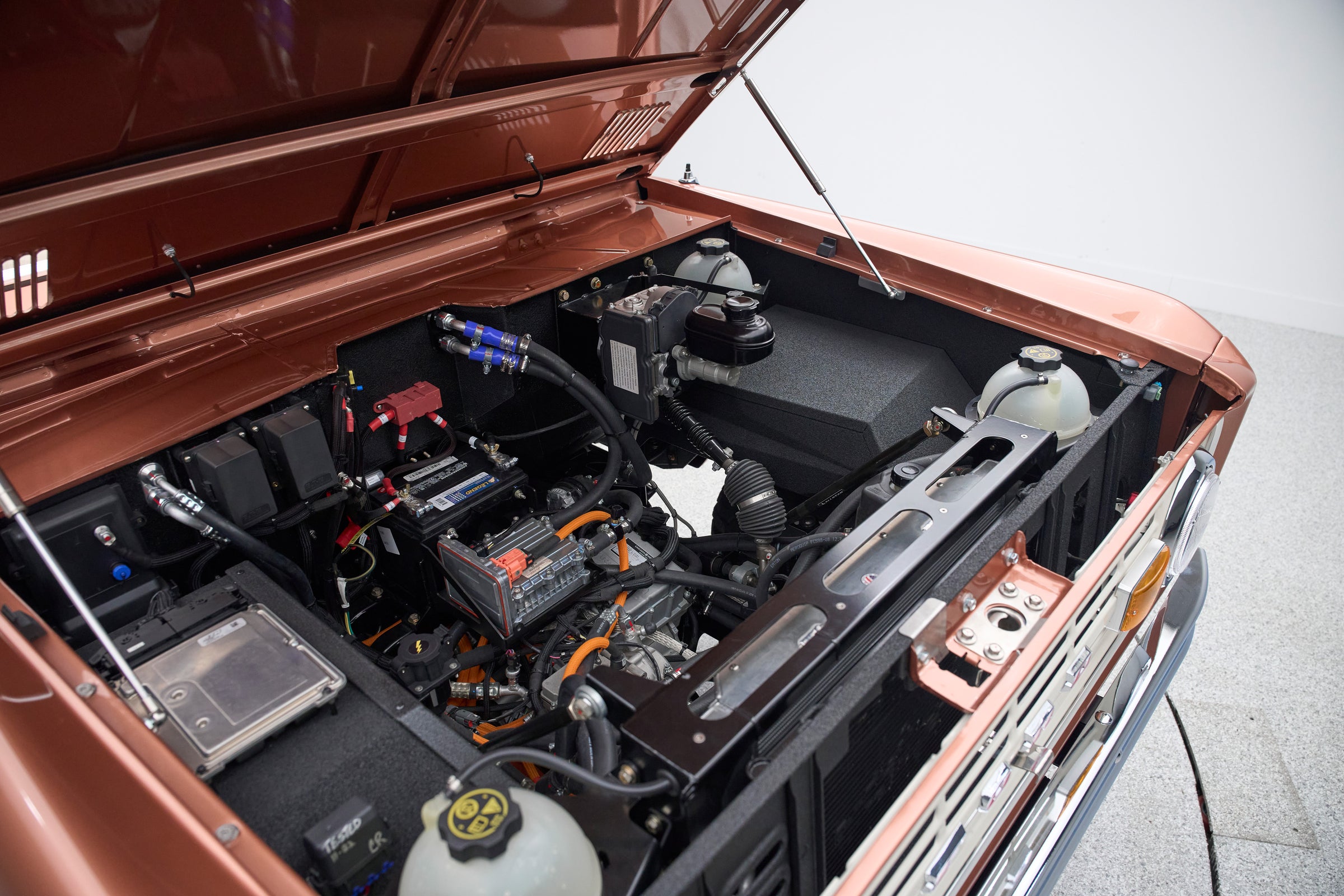Engine compartment of Classic Ford Bronco featuring an electric motor and battery components