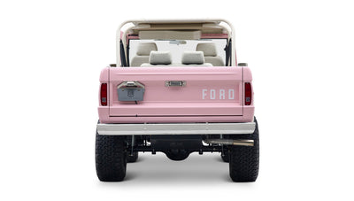 Rear view of Classic Ford Bronco in pink with white interior seats and visible suspension