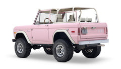 Rear three-quarter view of pink Classic Ford Bronco angled slightly differently showing suspension and tires