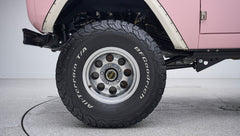 Close-up of BFGoodrich All-Terrain T/A tire and shiny multi-hole aluminum wheel on Classic Ford Bronco