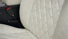 Close-up of diamond-stitched beige upholstery on the seat of a Classic Ford Bronco