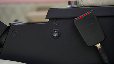 Black control panel featuring a heated seat button and a seatbelt latch in a Classic Ford Bronco