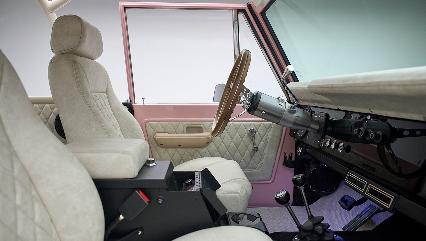 Interior view of Classic Ford Bronco with beige quilted seats and pink door frame