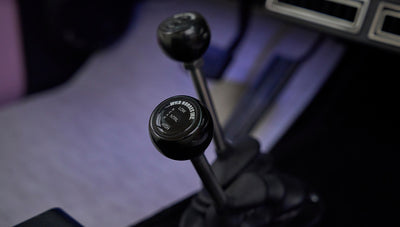 Close-up of two black gear shifters labeled Wild Horses Inc in Classic Ford Bronco