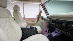 Interior side view of Classic Ford Bronco showing beige seats and quilted pink door