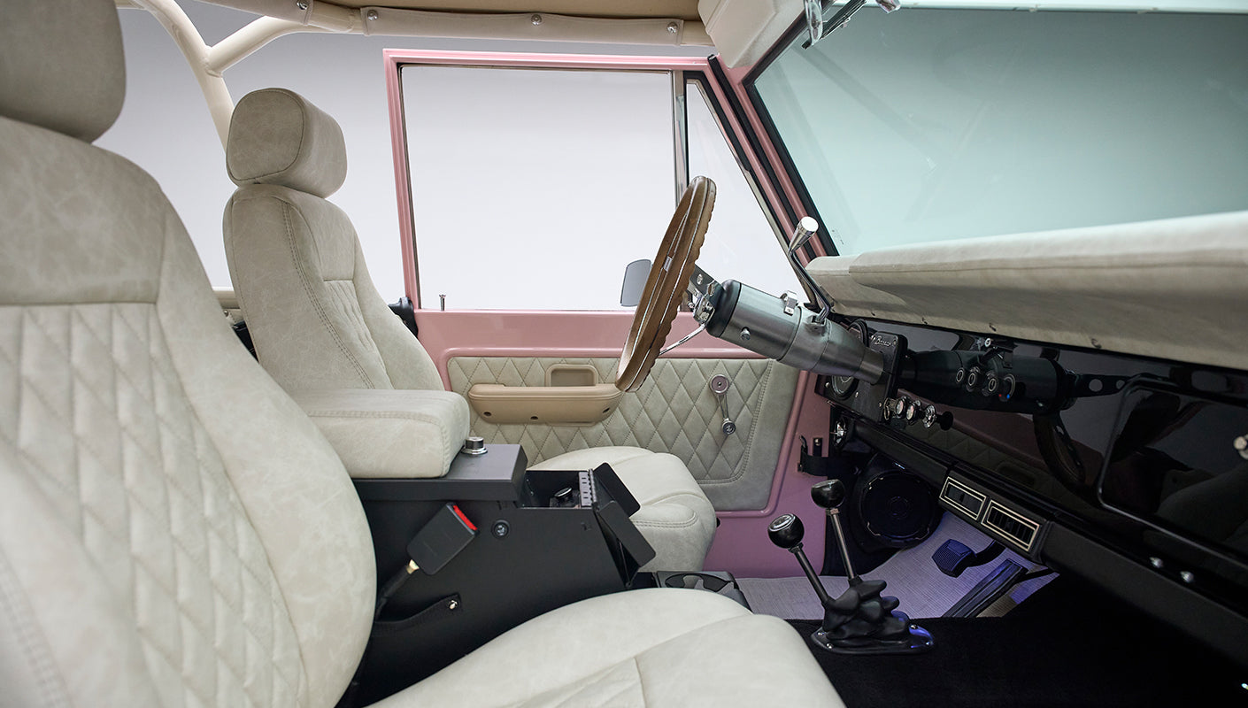 Interior side view of Classic Ford Bronco showing beige seats and quilted pink door