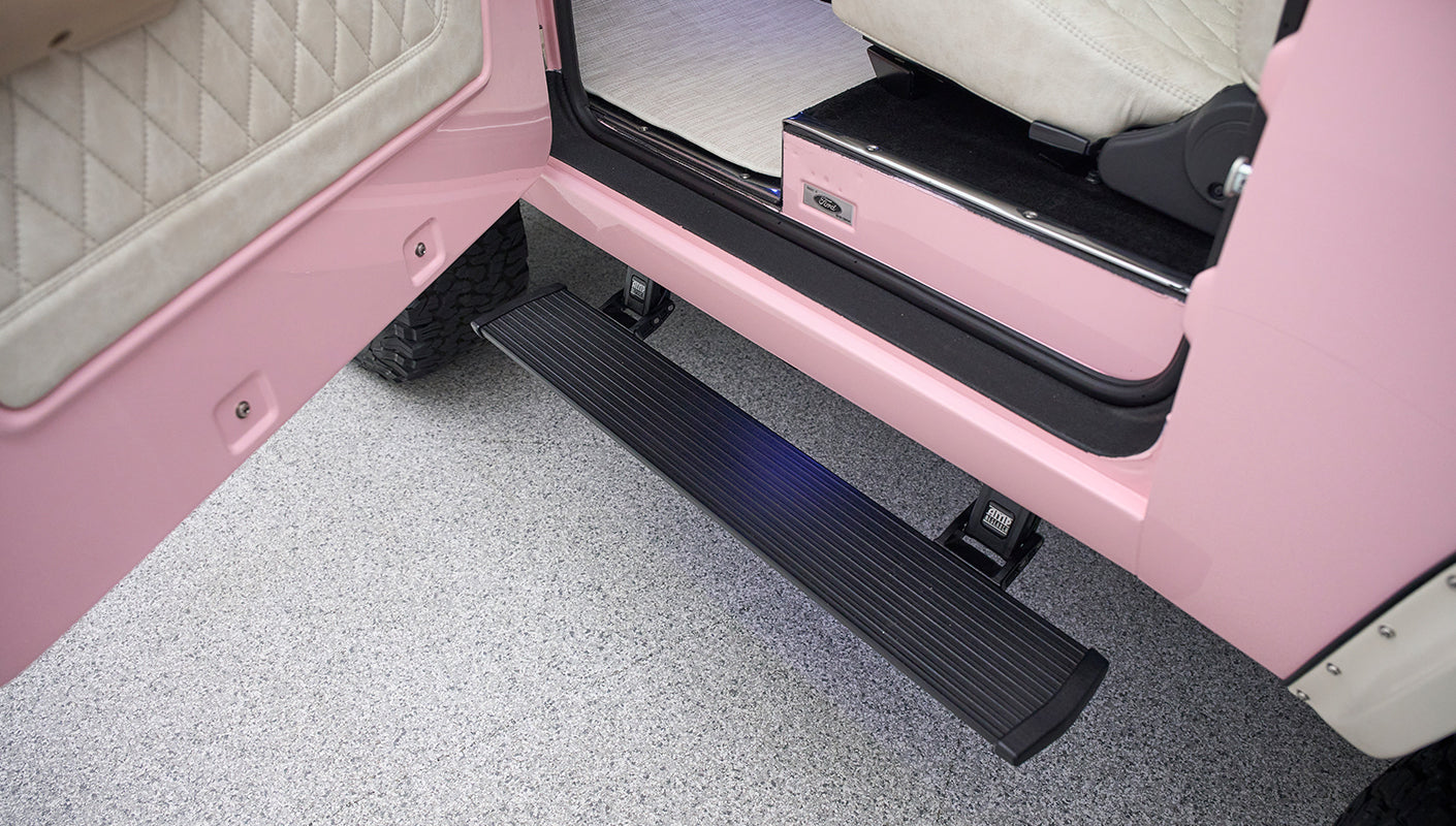 Side step and open door showing pink exterior and black step of Classic Ford Bronco