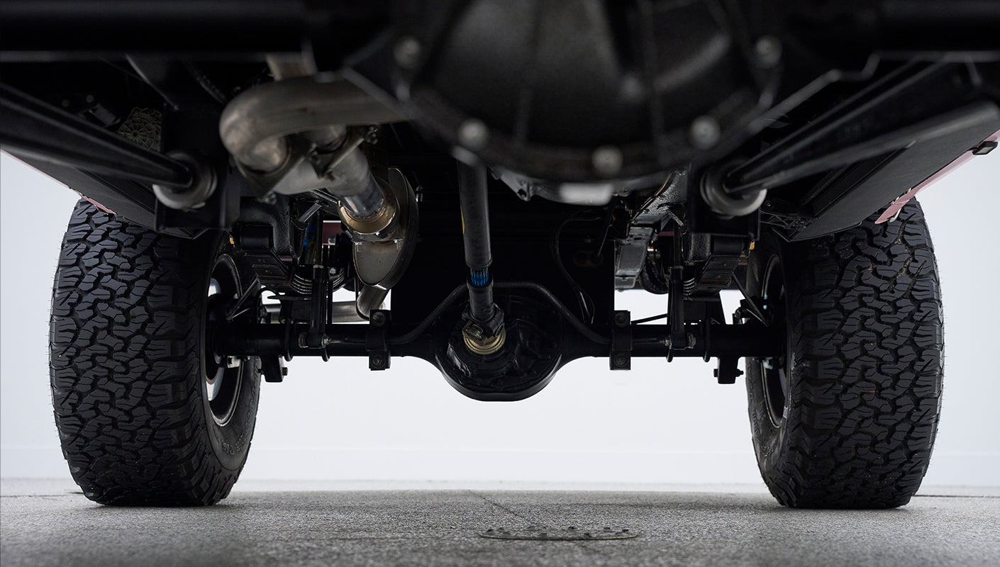 Underneath view of rear axle and differential of Classic Ford Bronco with tires visible