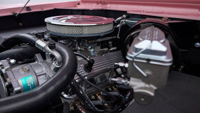 Close-up of engine and brake booster in a pink Classic Ford Bronco with hood open