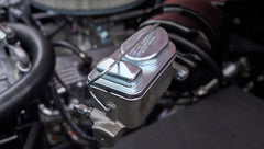 Close-up of brake master cylinder in engine compartment of pink Classic Ford Bronco