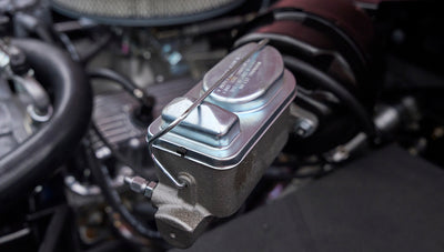 Close-up of brake master cylinder in engine compartment of pink Classic Ford Bronco