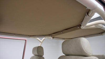 View of beige fabric roof frame and upholstery inside pink Classic Ford Bronco