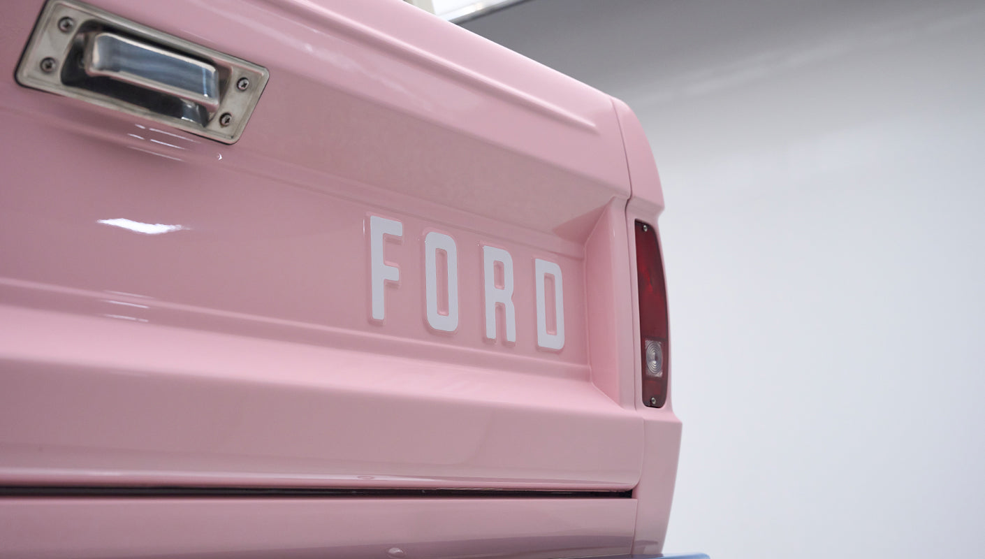 Close-up of rear tailgate of pink Classic Ford Bronco with white Ford lettering