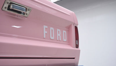Close-up of rear tailgate of pink Classic Ford Bronco with white Ford lettering