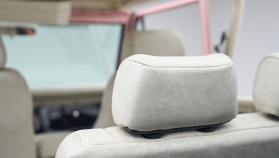 Cream-colored headrest inside a Classic Ford Bronco, visible through the open driver door.