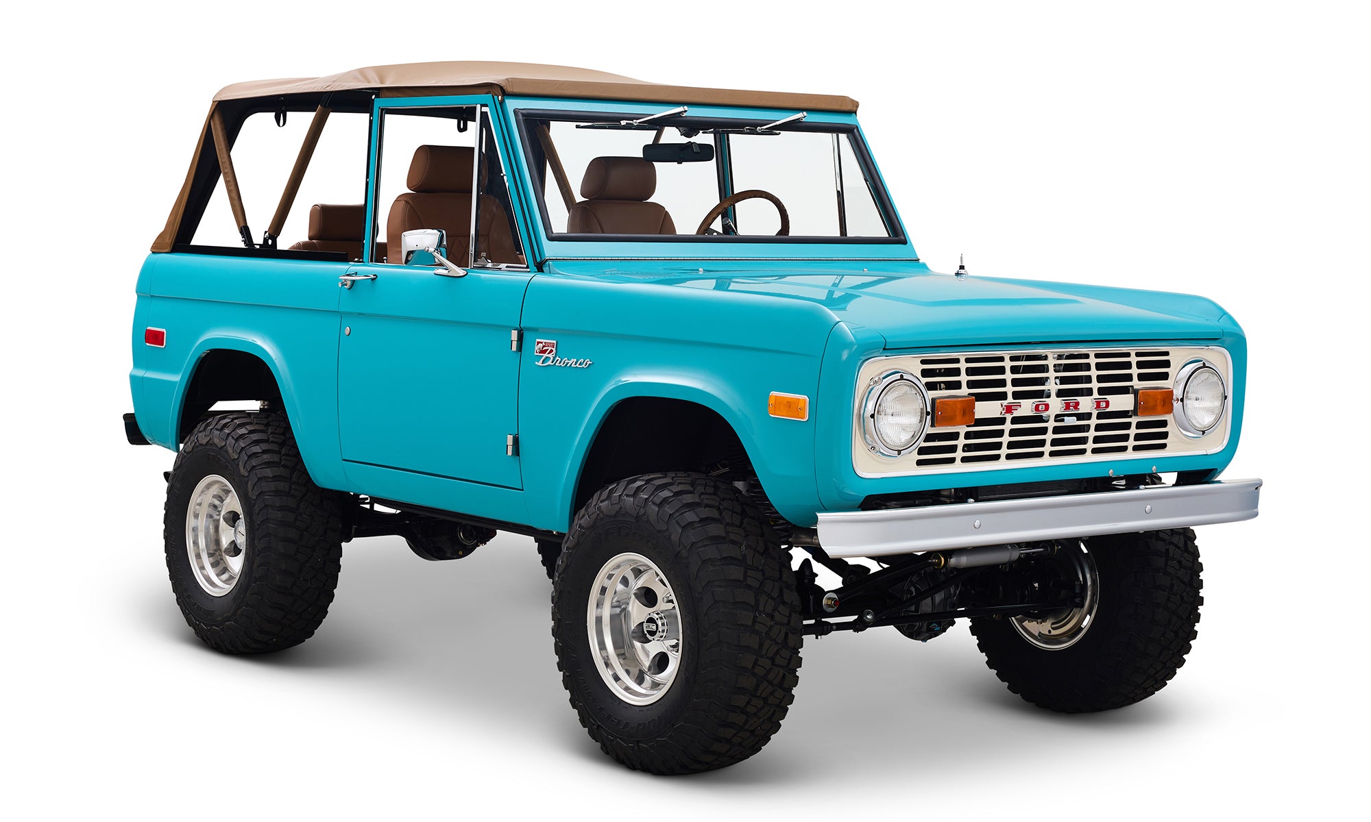 Classic Ford Bronco in peacock blue with tan soft top, lifted suspension, and off-road tires.