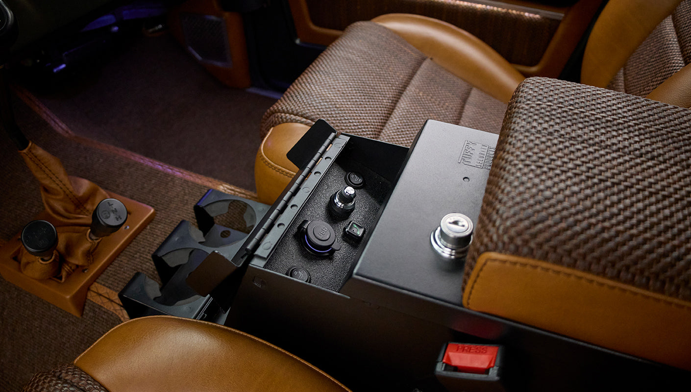 Classic Ford Bronco center console with cup holders and leather-wrapped gear shifters beside front seats