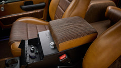 Classic Ford Bronco center console armrest covered in brown woven fabric and leather with lock mechanism