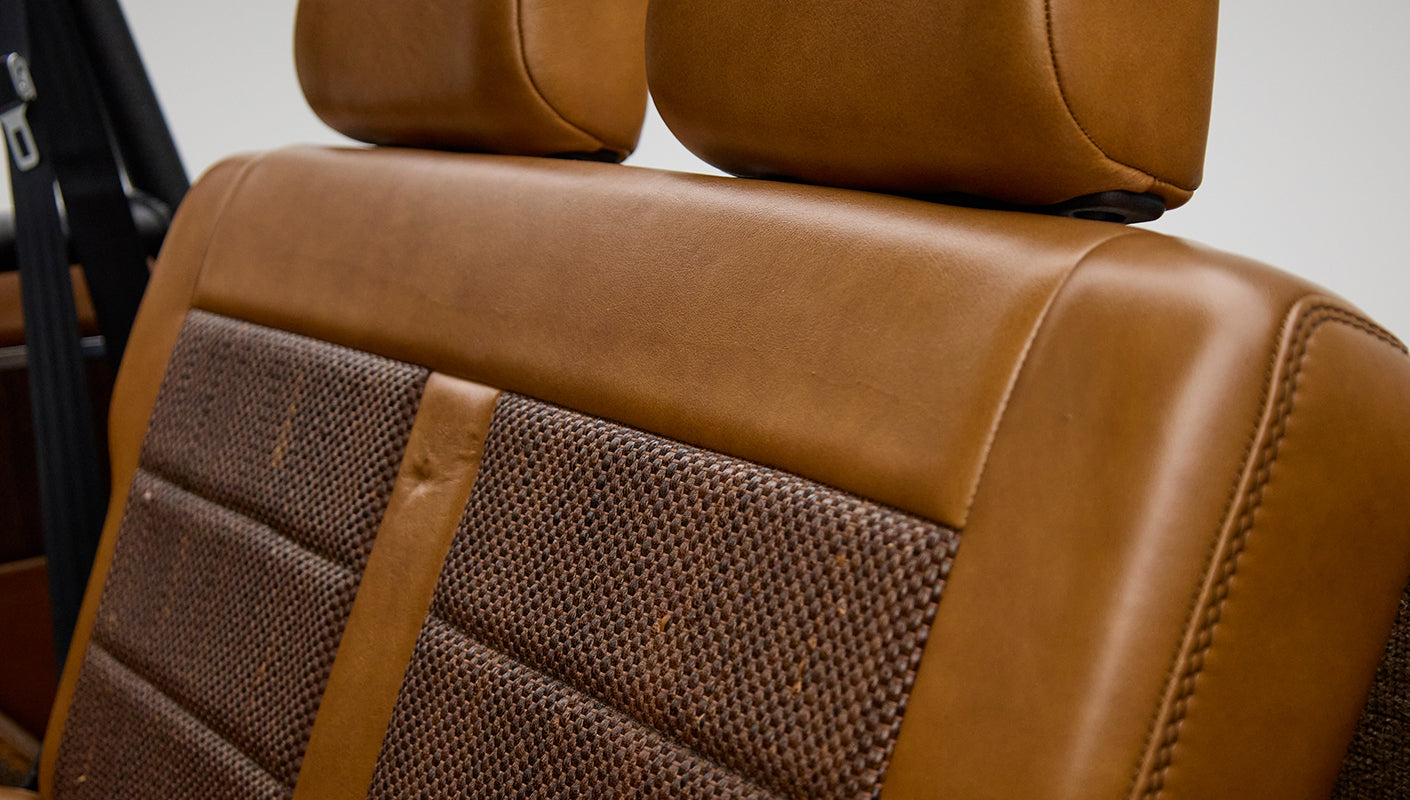 Close-up of Classic Ford Bronco rear seatback with brown leather and woven textured fabric upholstery