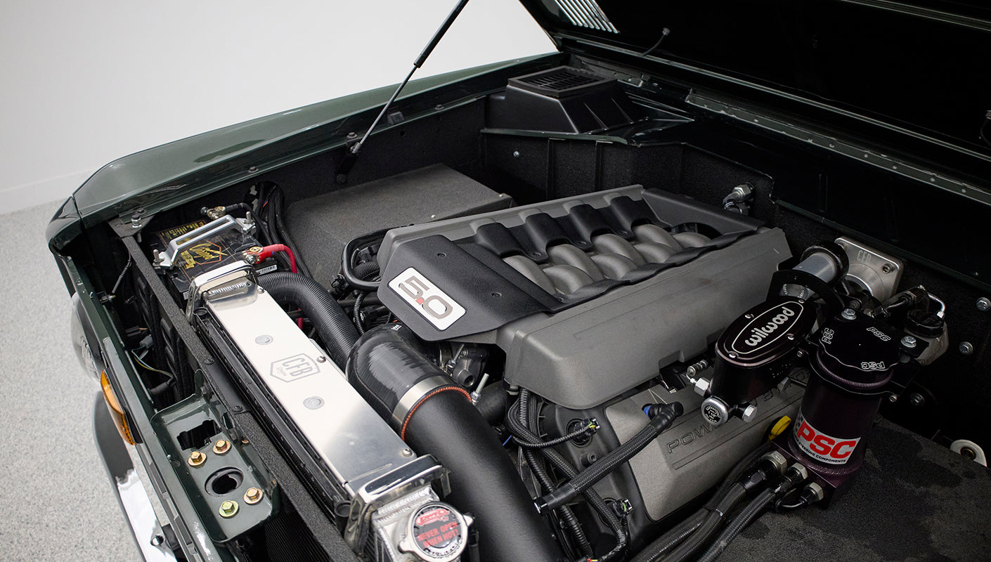 Close-up of Classic Ford Bronco engine with 5.0 liter engine cover and polished radiator