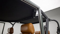 View inside Classic Ford Bronco showing black roll cage and tan leather headrest