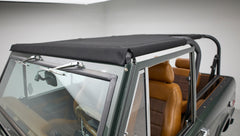 Classic Ford Bronco front windshield and black soft top with tan leather seats visible