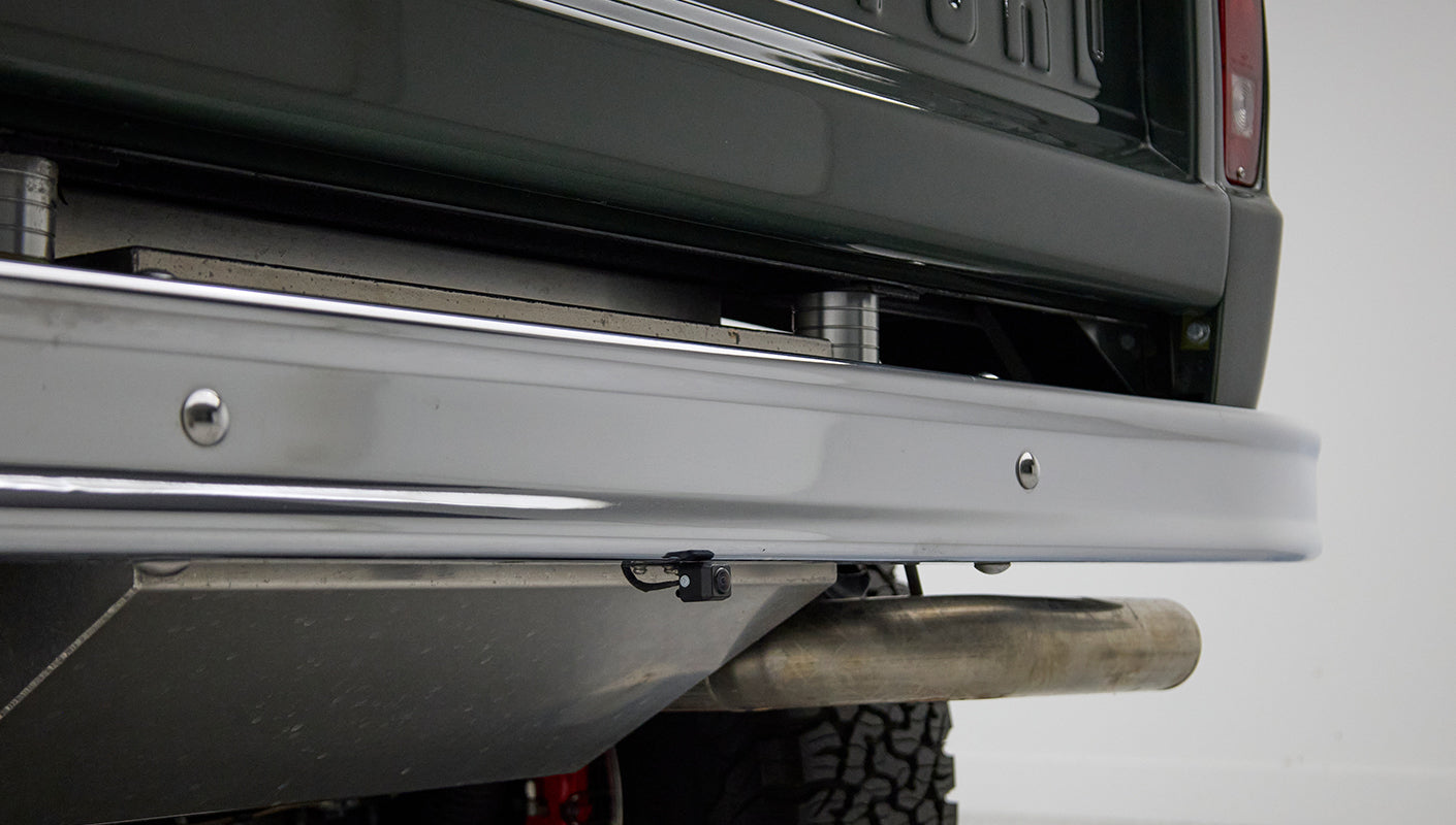 Close-up of rear bumper and exhaust pipe with backup camera on Classic Ford Bronco