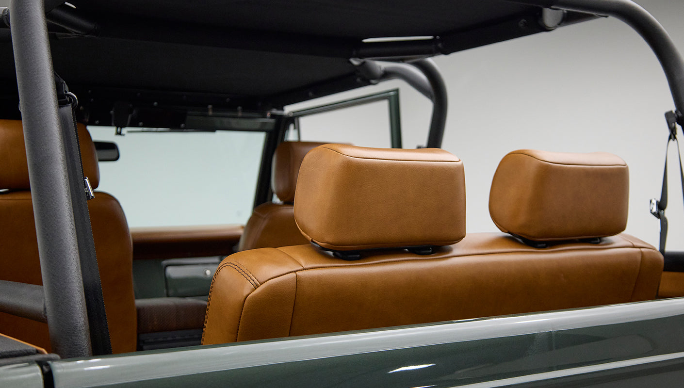 View of tan leather headrests and black roll cage inside Classic Ford Bronco
