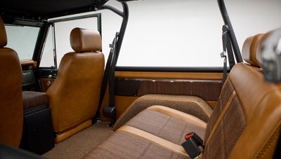 Interior rear seating area of Classic Ford Bronco with tan leather and brown cloth upholstery