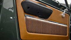Close-up of door panel with black armrest and brown woven lower panel in Classic Ford Bronco