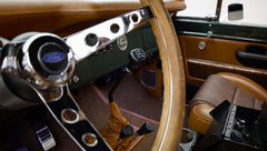Steering wheel with Ford logo, gear levers, and driver's seat upholstery in Classic Ford Bronco