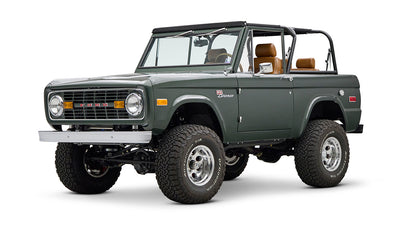 Classic Ford Bronco dark green front left angled view with round headlights and open roof.
